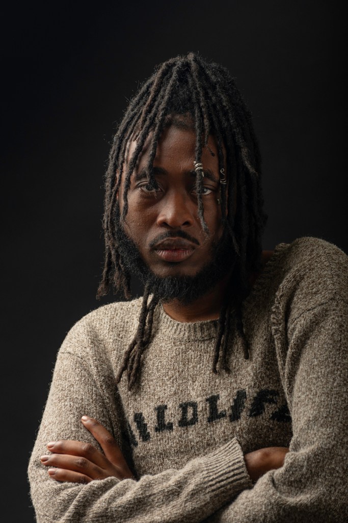 man in a sweater with arms crossed. studio photography.