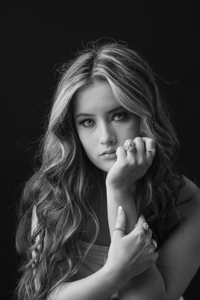 woman rests her head on her fist. studio photography.