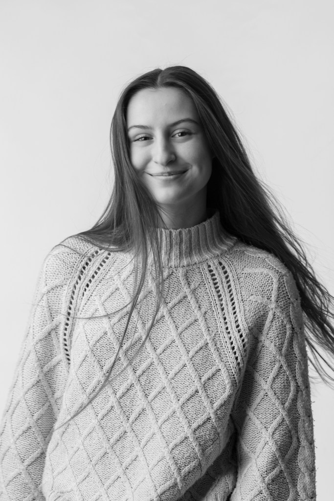Young woman with her hair flowing and smiling.
