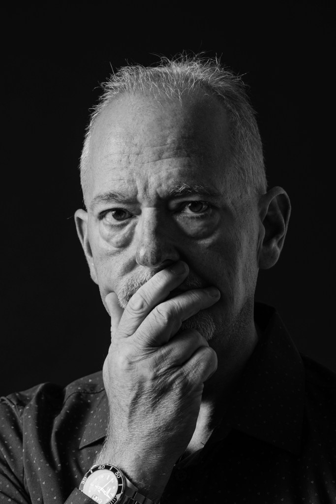 Middle aged man covers his mouth with his hand. studio photography.