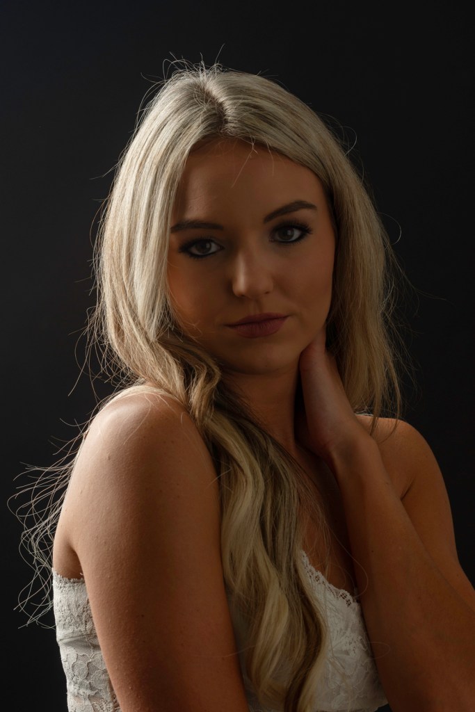 woman rests her hand on her neck. studio photography.
