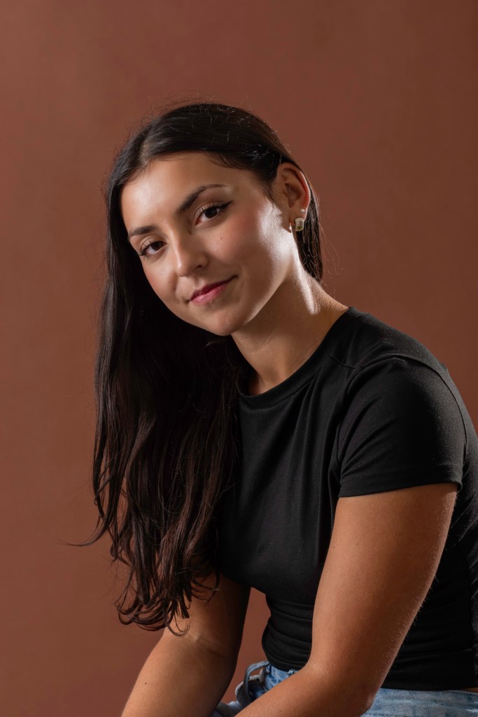 woman drapes her hair over her shoulder. studio photography.