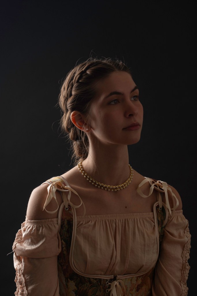 woman with braided hair looks to the right. studio photography.