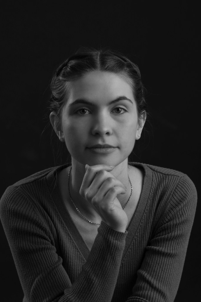 woman with braided hair touches her chin. studio photography.