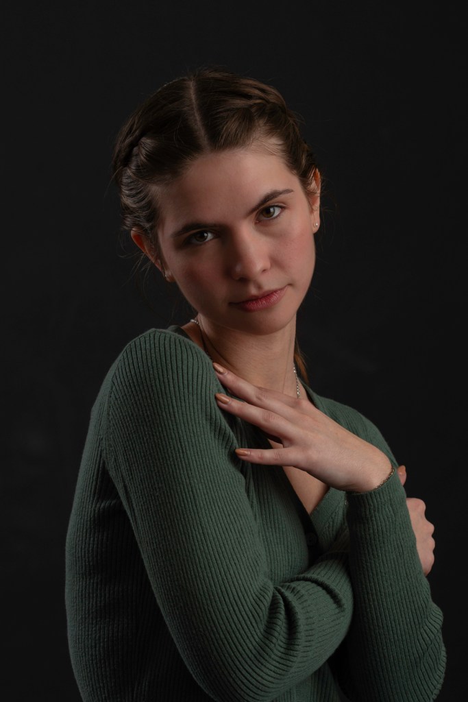 Young woman fashion pose in green sweater. studio photography.