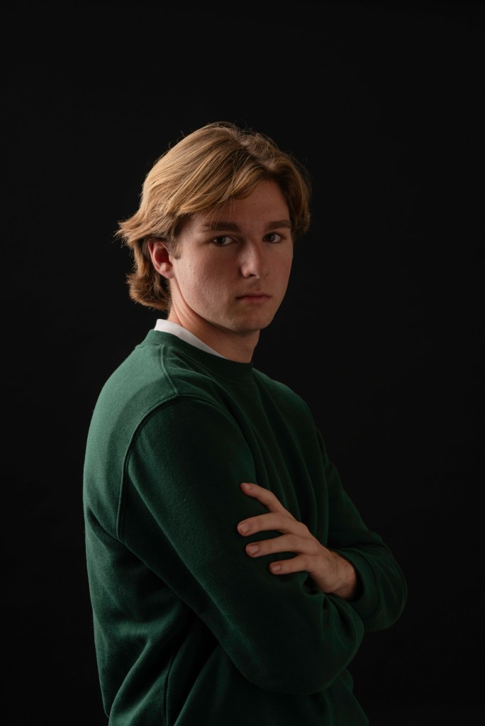 man stands with his arms crossed. studio photography.